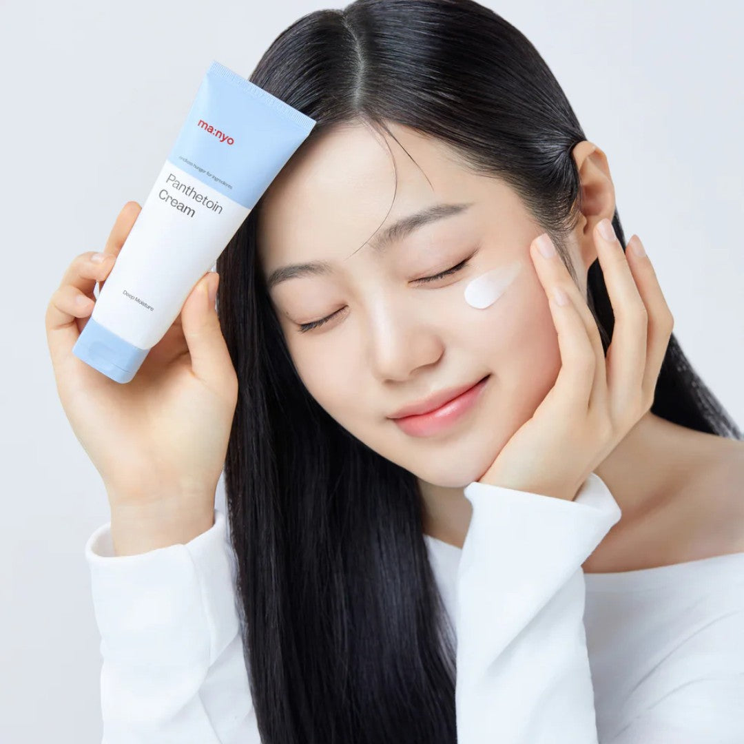 ma:nyo Panthetoin Cream 80ml displayed by a smiling model applying the cream to her face.