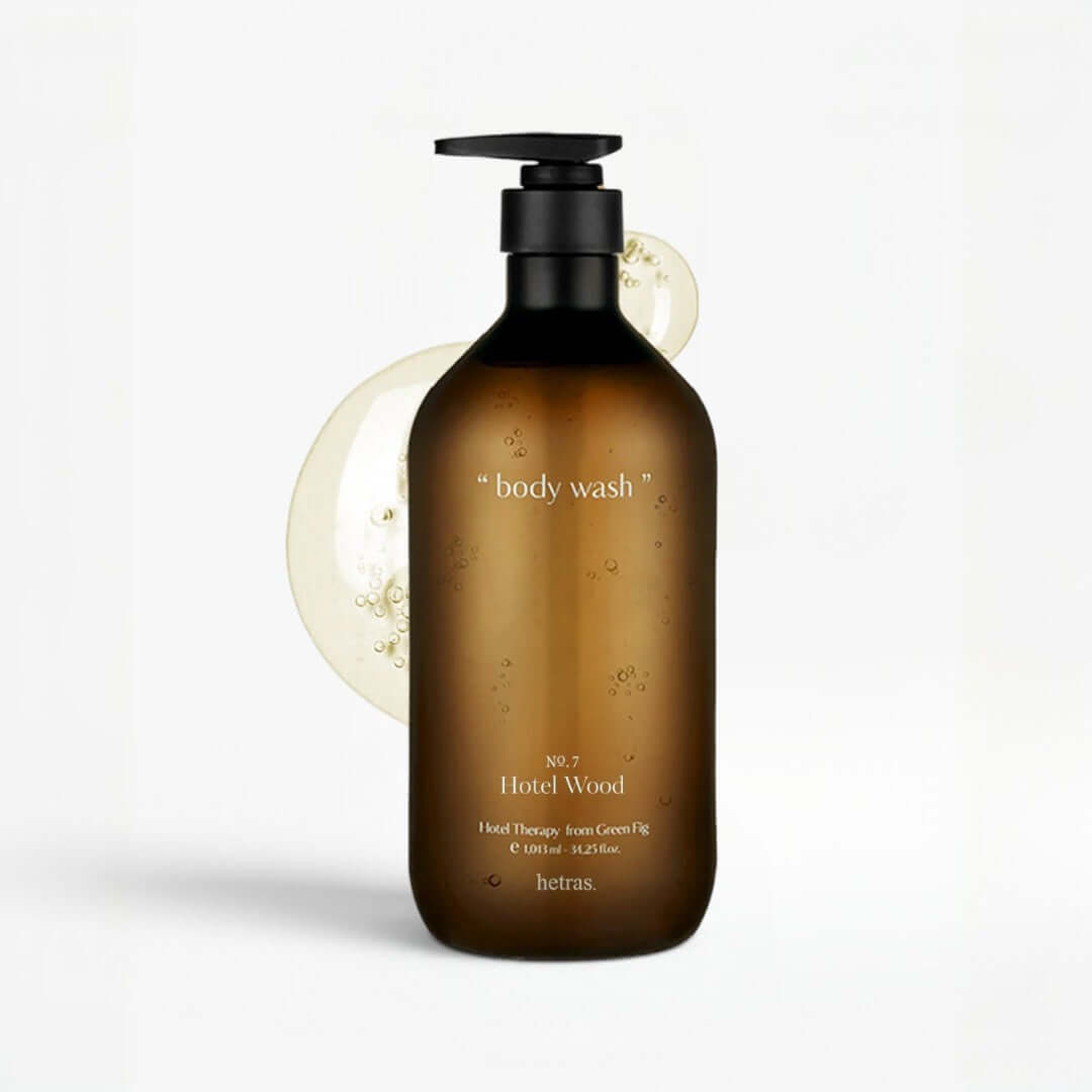 Brown bottle of body wash labeled 'Hotel Wood' on a white background