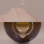 ma:nyo Bifida Biome Complex Ampoule 50ml dropping onto hand from bottle, showcasing its nourishing formula.
