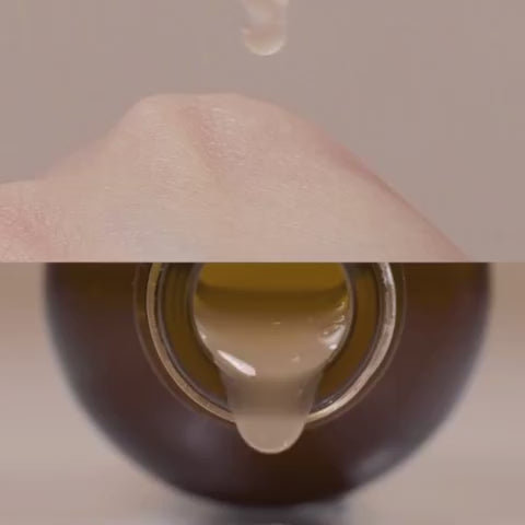 ma:nyo Bifida Biome Complex Ampoule 50ml dropping onto hand from bottle, showcasing its nourishing formula.